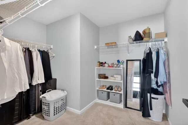a view of walk in closet with clothes and shoes