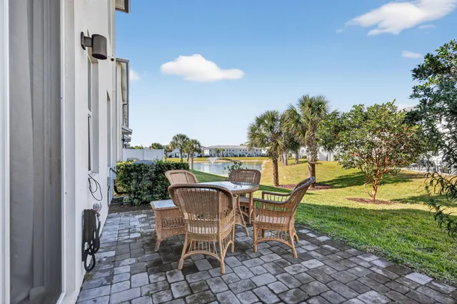 a patio with table and chairs and potted plants