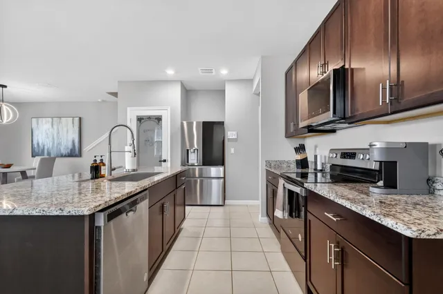 a kitchen with stainless steel appliances granite countertop a sink stove and refrigerator