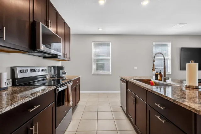 a kitchen with stainless steel appliances a sink stove and cabinets