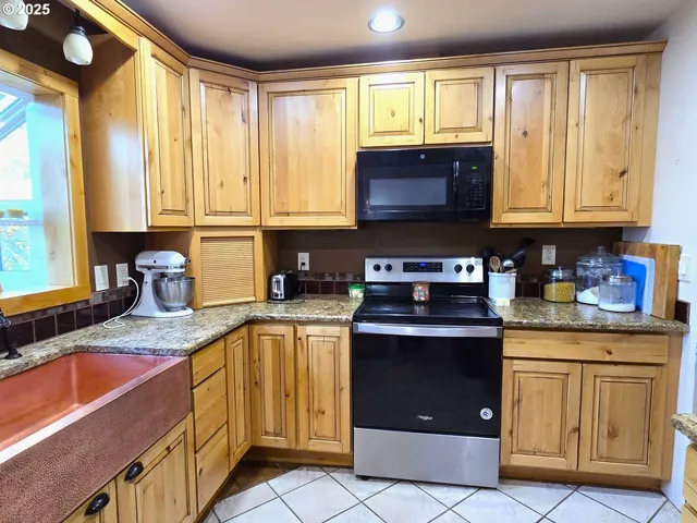 a kitchen with stainless steel appliances granite countertop a stove a sink and a microwave