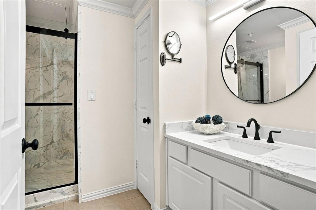 2601 Preston Road, Unit 4103 Plano, TX 75093 - Photo 11 of 16 Shower with sliding glass enclosure, marble-style tile surround, and black hardware
