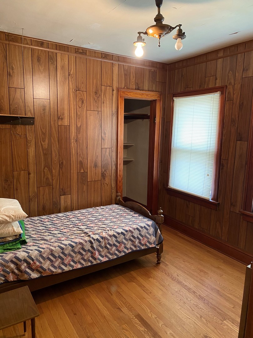 3112 Chicago Road Steger, IL 60475 - Photo 8 of 15 a bedroom with a bed and a chandelier