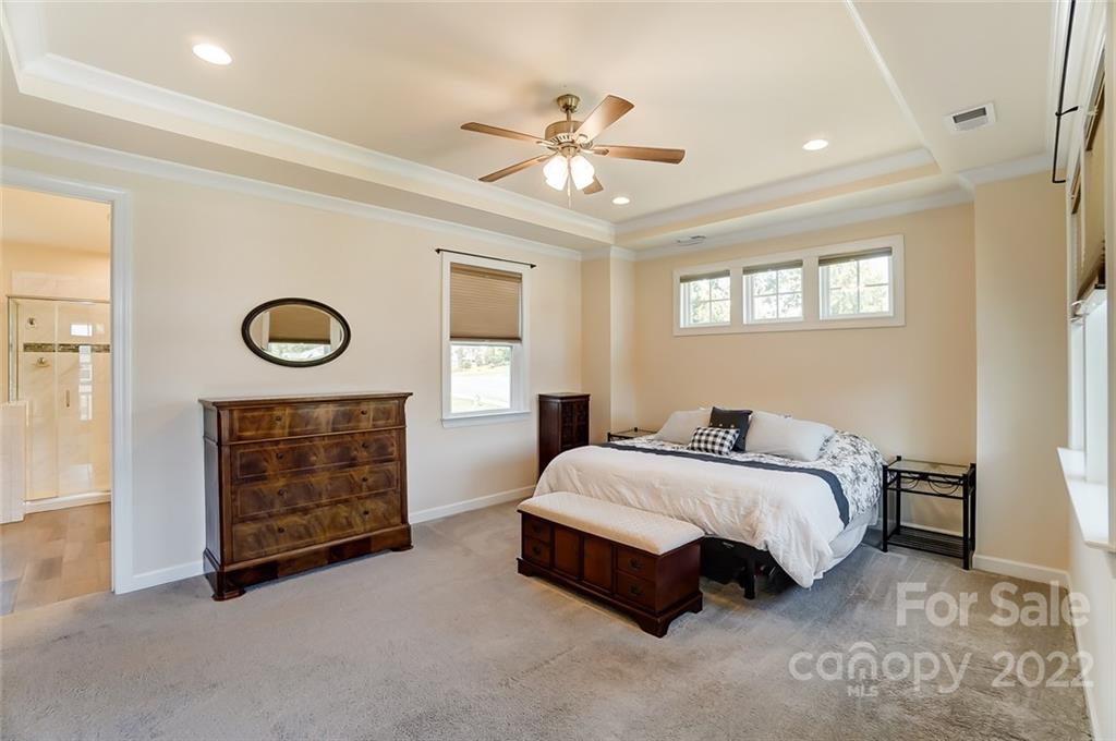 421 Sandbar Point Lake Wylie, SC 29710 - Photo 29 of 48 a spacious bedroom with a bed and a chandelier