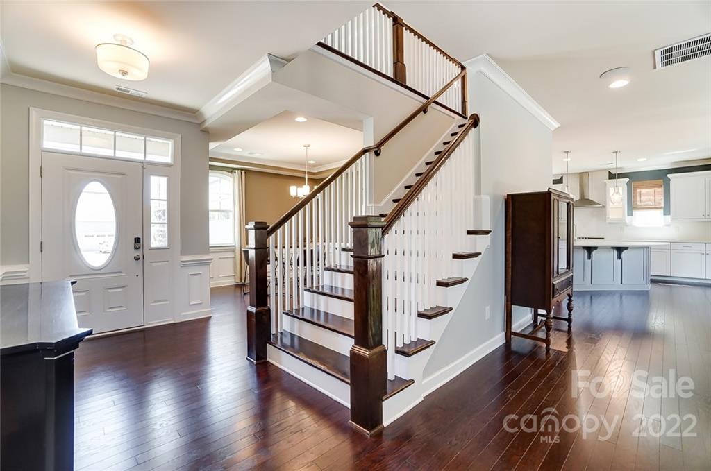 421 Sandbar Point Lake Wylie, SC 29710 - Photo 3 of 48 a view of a hallway with wooden floor staircase and a kitchen