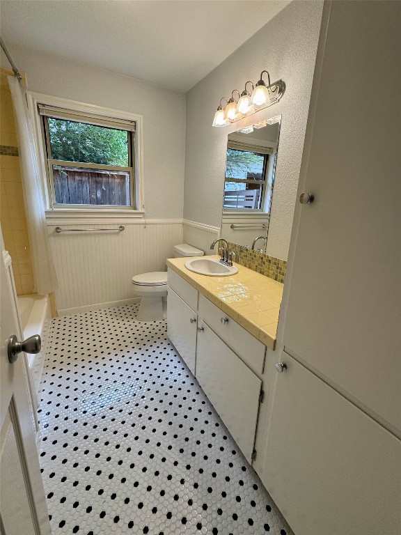 1009 Alegria Road Austin, TX 78757 - Photo 21 of 27 a bathroom with a sink a toilet a window a vanity and mirror