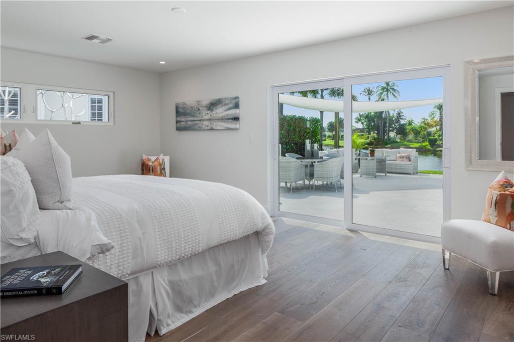 512 Whispering Pine Lane Naples, FL 34103 - Photo 12 of 24 a bedroom with a bed and a couch