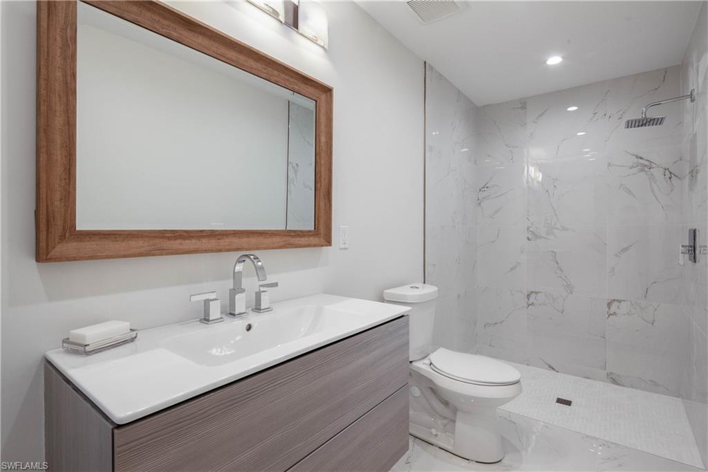 512 Whispering Pine Lane Naples, FL 34103 - Photo 15 of 24 a bathroom with a sink toilet and shower