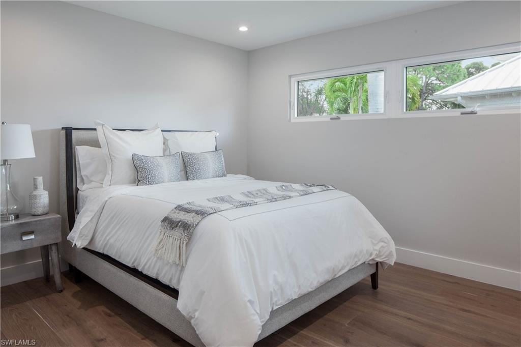 512 Whispering Pine Lane Naples, FL 34103 - Photo 16 of 24 a large bed sitting in a bedroom next to a window