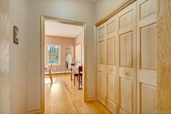 a view of a hallway with wooden floor and dining room