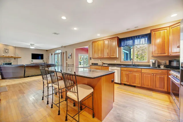 a kitchen with stainless steel appliances granite countertop wooden floor dining table and chairs