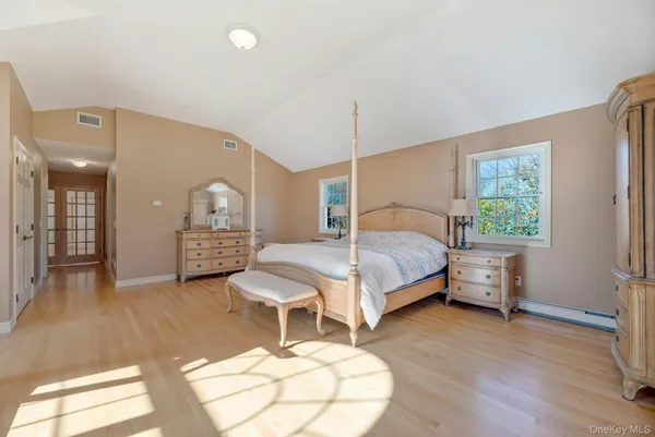 a bedroom with a bed a table and painting on the wall