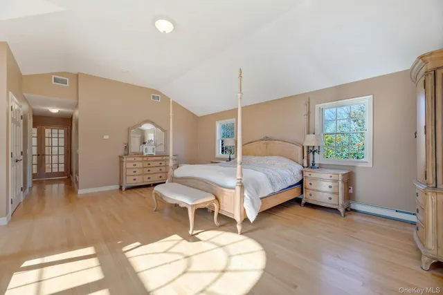 a bedroom with a bed a table and painting on the wall