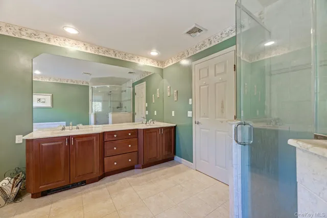 a bathroom with a sink mirror and shower