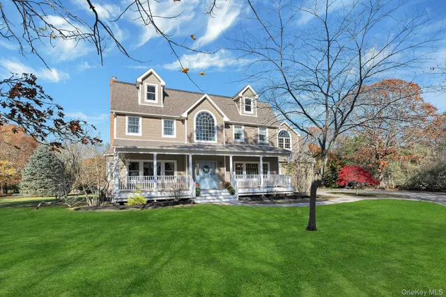 a front view of a house with a garden and trees