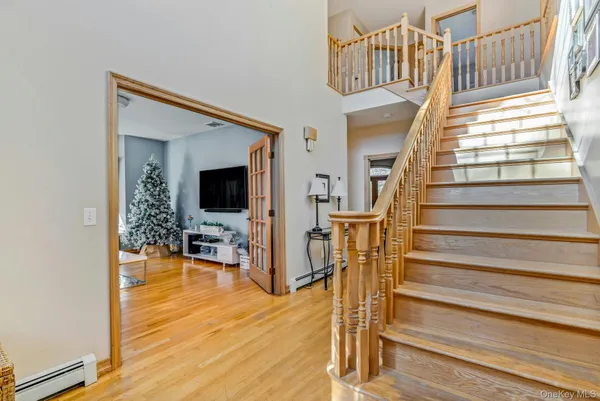 a view of entryway and hall with wooden floor