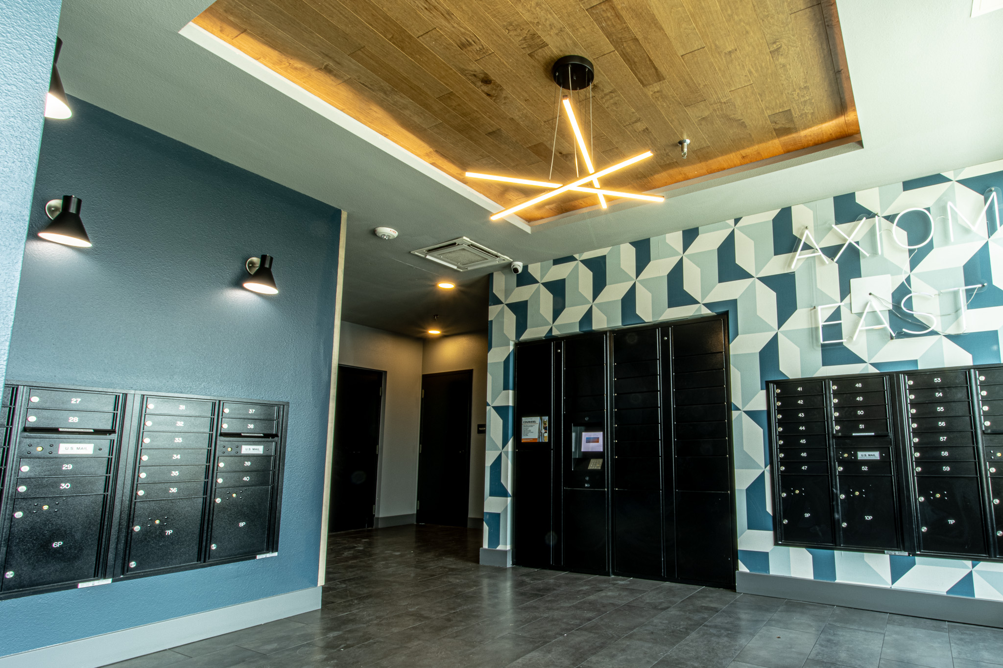 2220 Webberville Road, Unit 202 Austin, TX 78702 - Photo 21 of 27 Geometric wall patterns and a wood-paneled tray ceiling elevate this functional common space.
