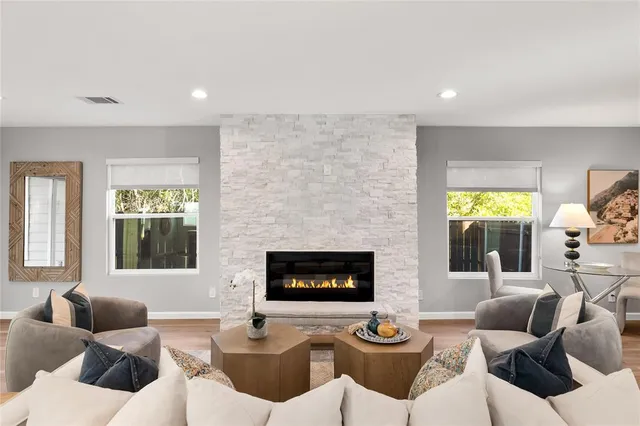 a kitchen with stainless steel appliances a dining table chairs refrigerator and cabinets