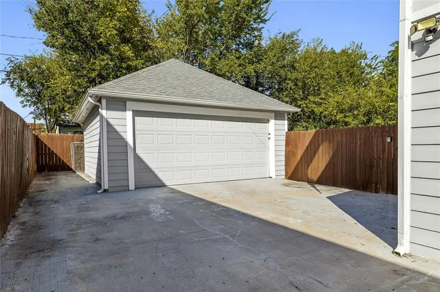 a front view of house with garage and trees