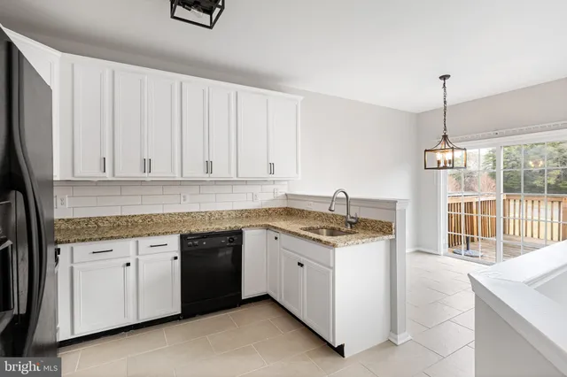 a kitchen with granite countertop a sink stove and refrigerator