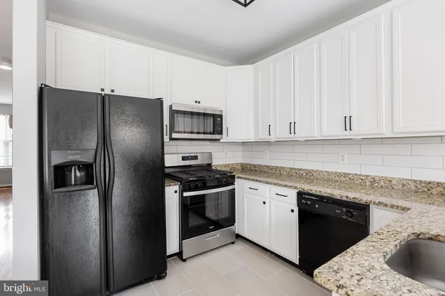 a kitchen with stainless steel appliances granite countertop a refrigerator and a sink