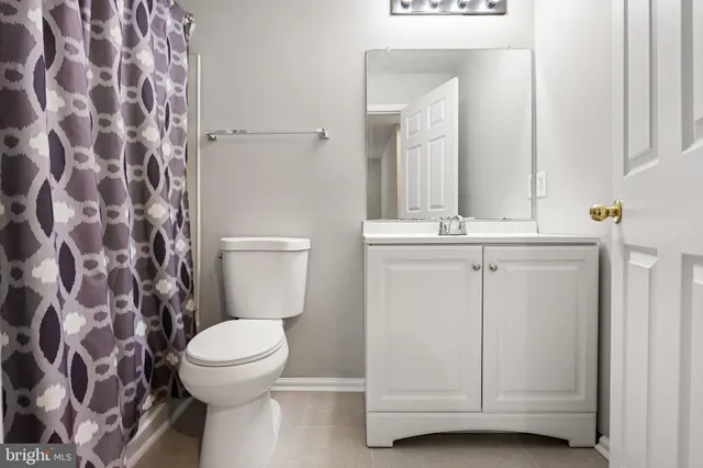 a living room with a fireplace and a ceiling fan