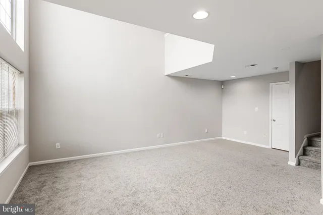 an empty room with windows and fireplace