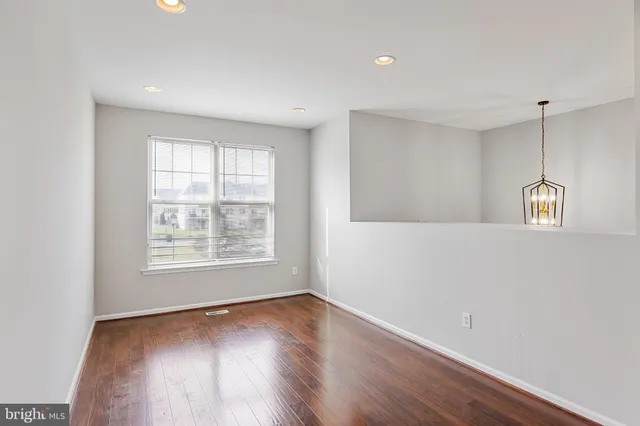 a view of a big room with wooden floor and windows