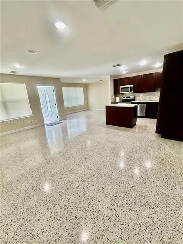a view of kitchen with microwave and refrigerator
