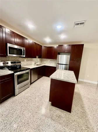 a kitchen with stainless steel appliances a stove a sink and a refrigerator