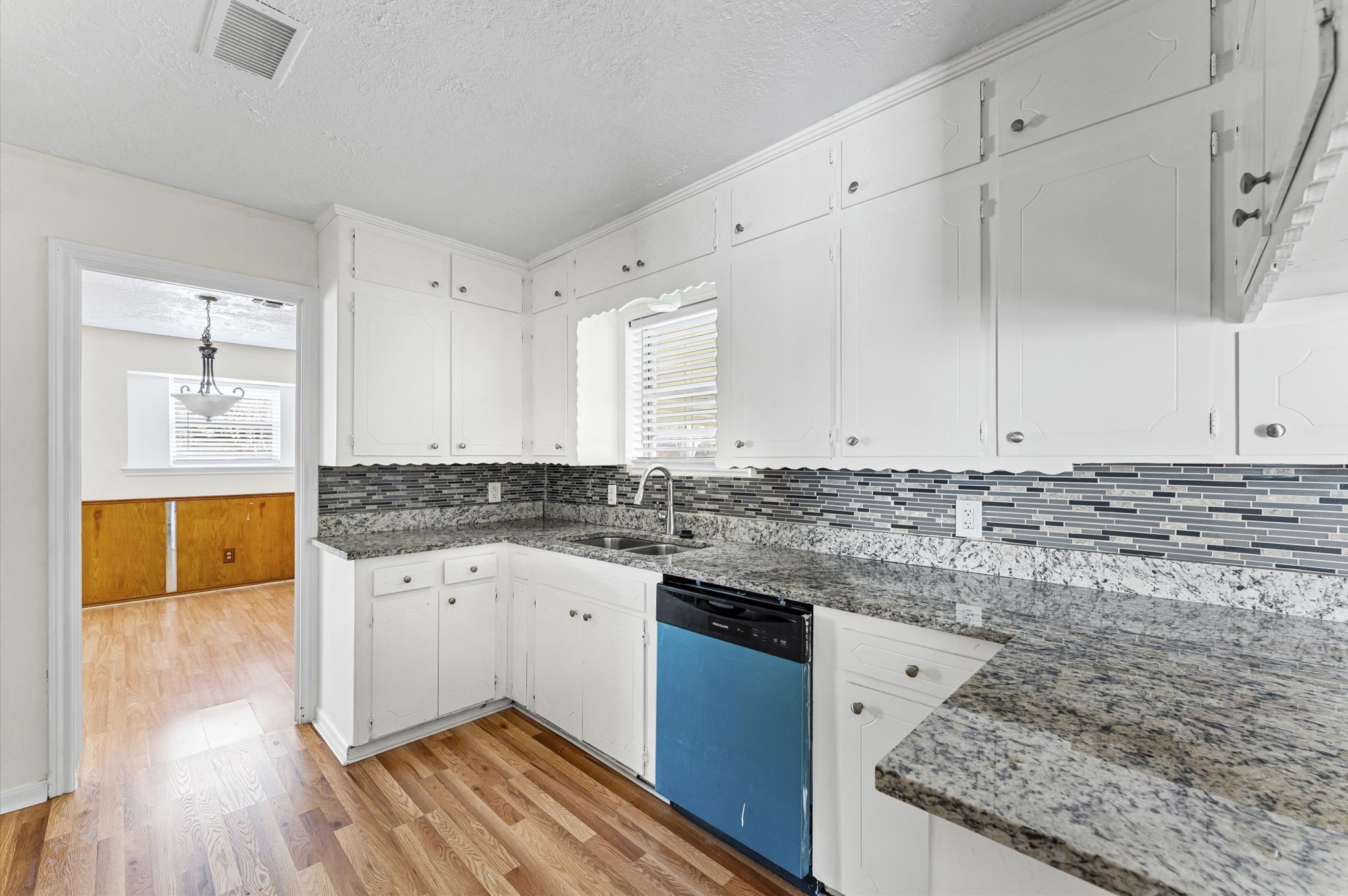 2709 Adams Street Alvin, TX 77511 - Photo 11 of 32 a kitchen with granite countertop a sink stove and cabinets