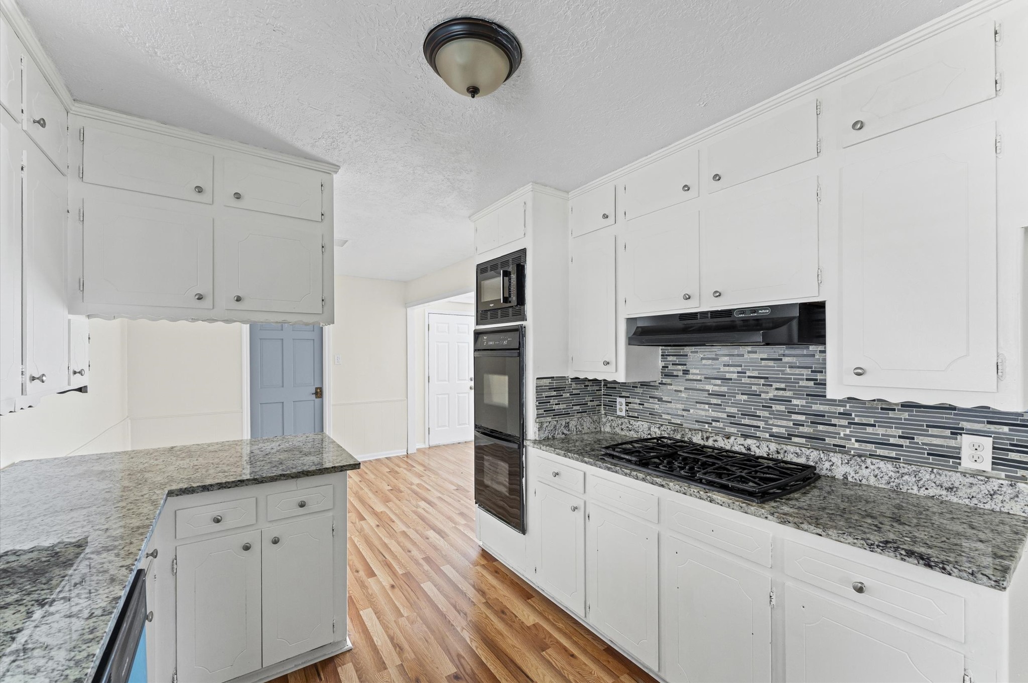 2709 Adams Street Alvin, TX 77511 - Photo 12 of 32 a kitchen with granite countertop white cabinets and stainless steel appliances