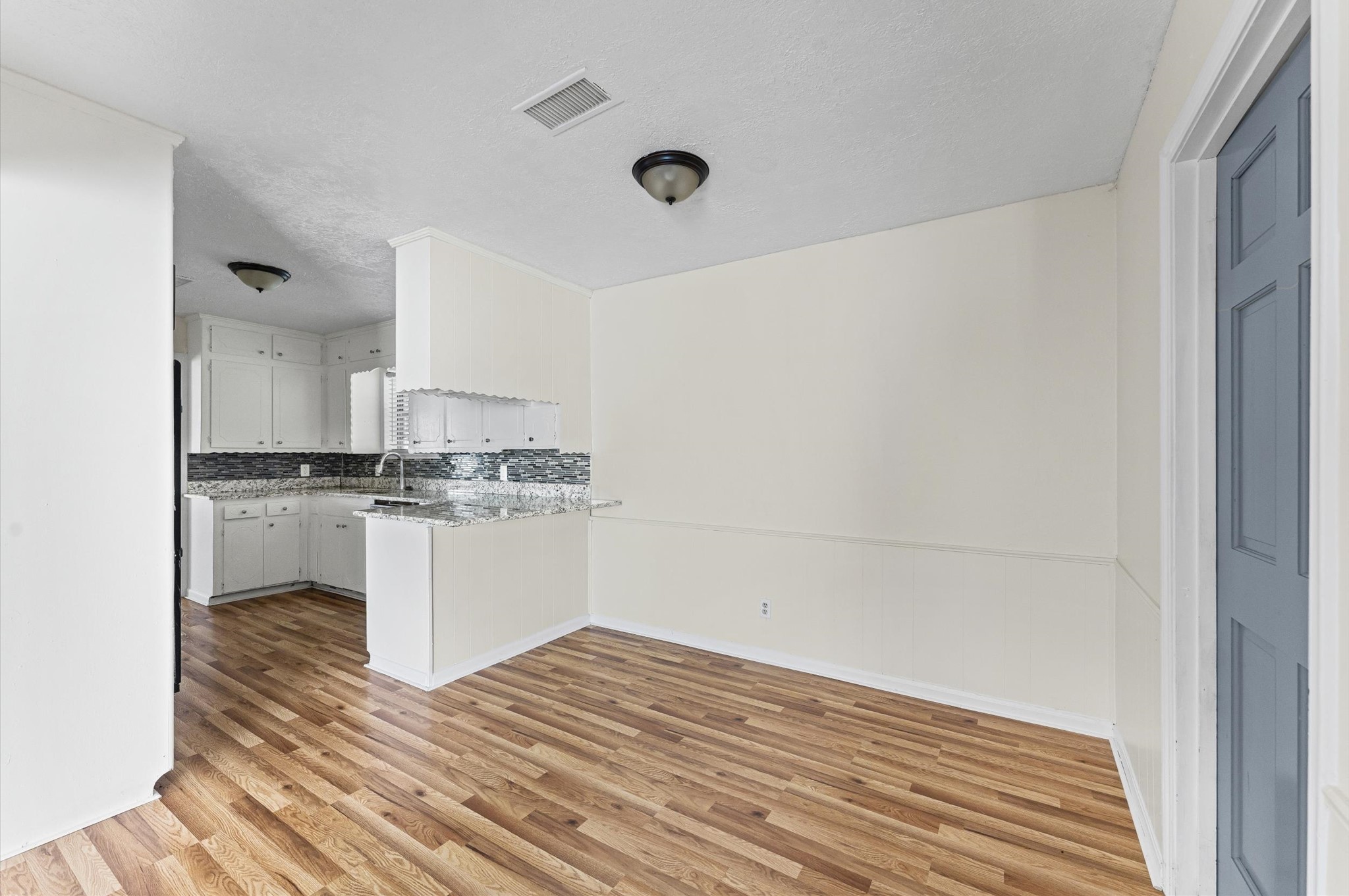 2709 Adams Street Alvin, TX 77511 - Photo 14 of 32 a kitchen with a refrigerator and white cabinets