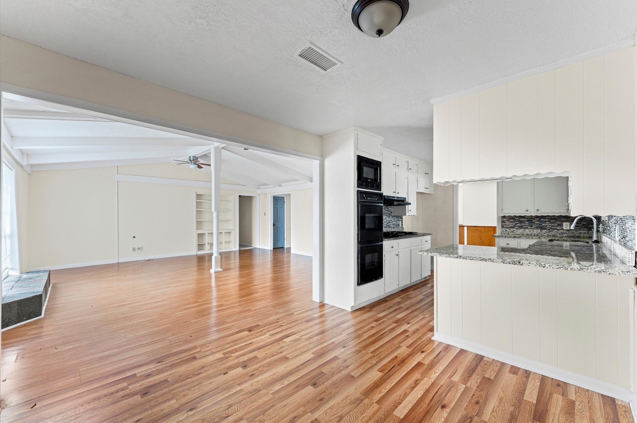 2709 Adams Street Alvin, TX 77511 - Photo 17 of 32 a view of a kitchen with a refrigerator a stove top oven and cabinets
