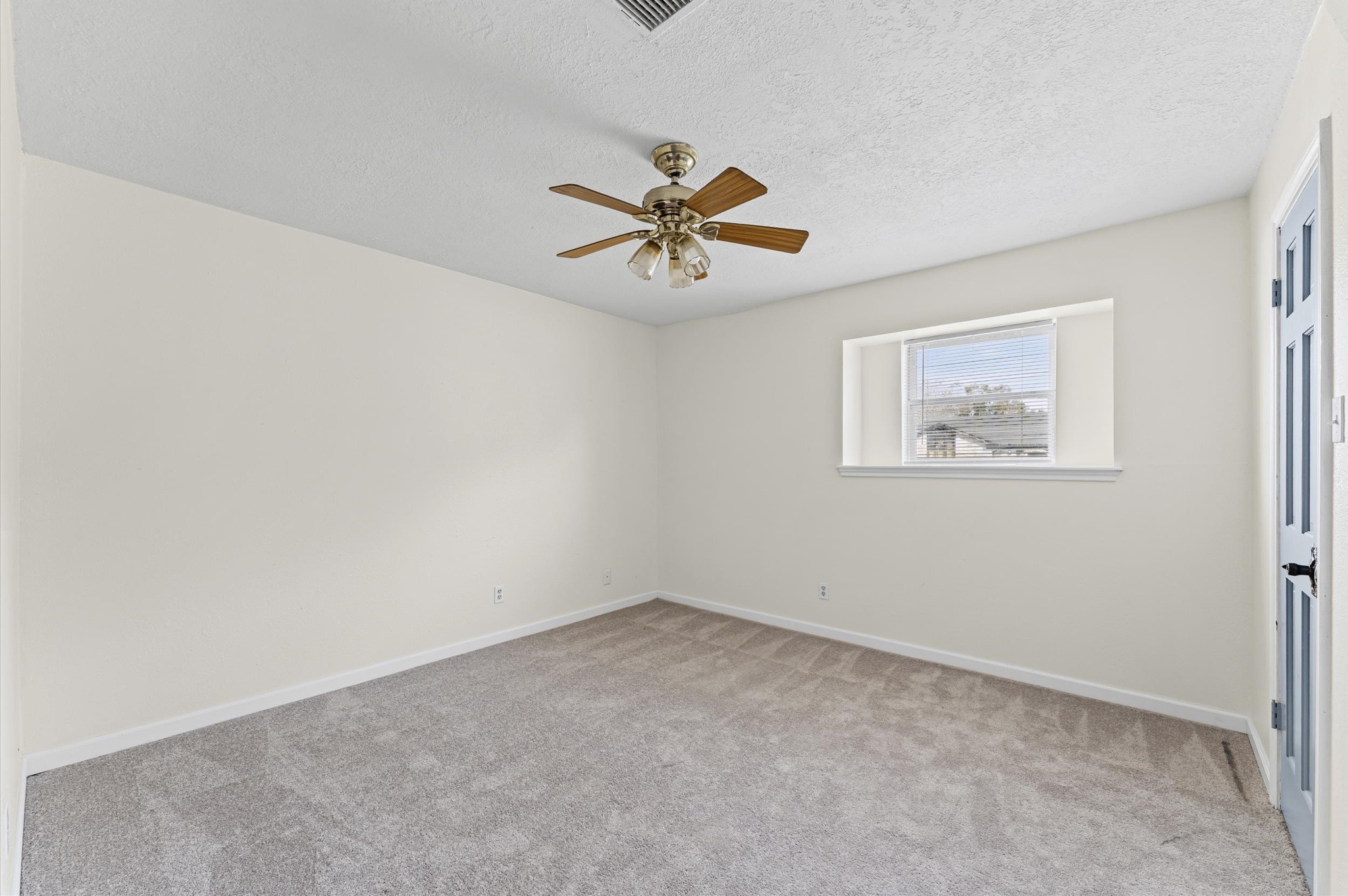 2709 Adams Street Alvin, TX 77511 - Photo 20 of 32 an empty room with a window and a ceiling fan
