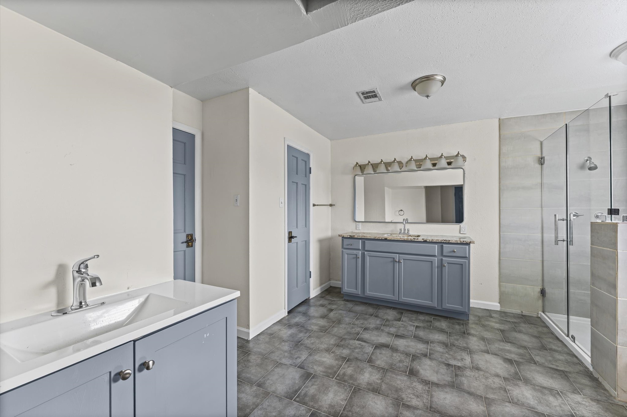 2709 Adams Street Alvin, TX 77511 - Photo 25 of 32 a large bathroom with a granite countertop sink a mirror and a bathtub