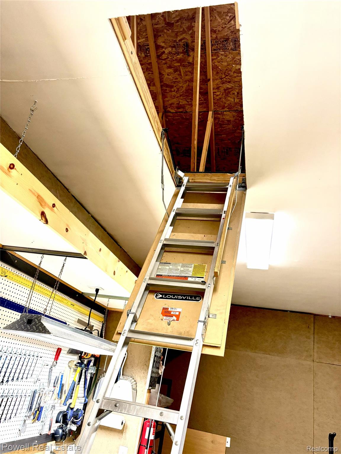 6807 Big Trail Road Holly, MI 48442 - Photo 40 of 45 Attic access with a pull-down ladder, featuring exposed ceiling joists and oriented strand board flooring