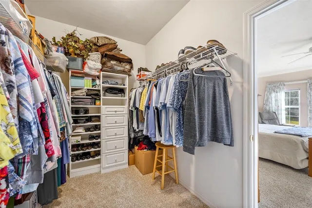 a view of walk in closet with clothes and shoes