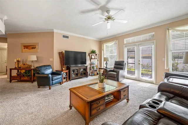 a living room with furniture a flat screen tv and a large window
