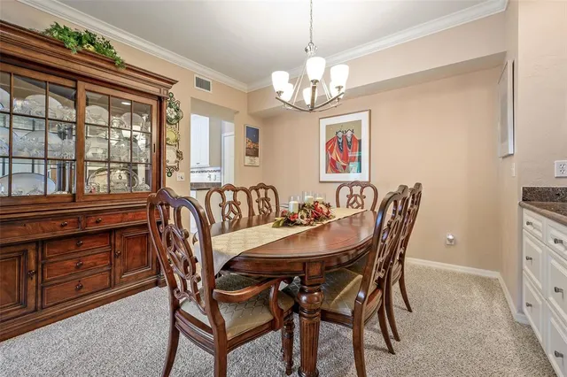 a view of a dining room with furniture a chandelier and wooden floor