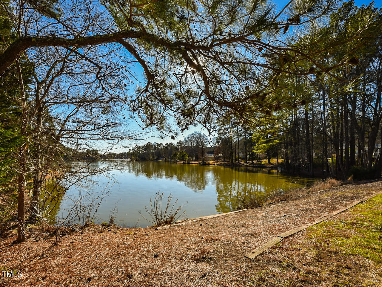 5200 Newhall Road Durham, NC 27713 - Photo 15 of 35 a wooden bench sitting next to a lake