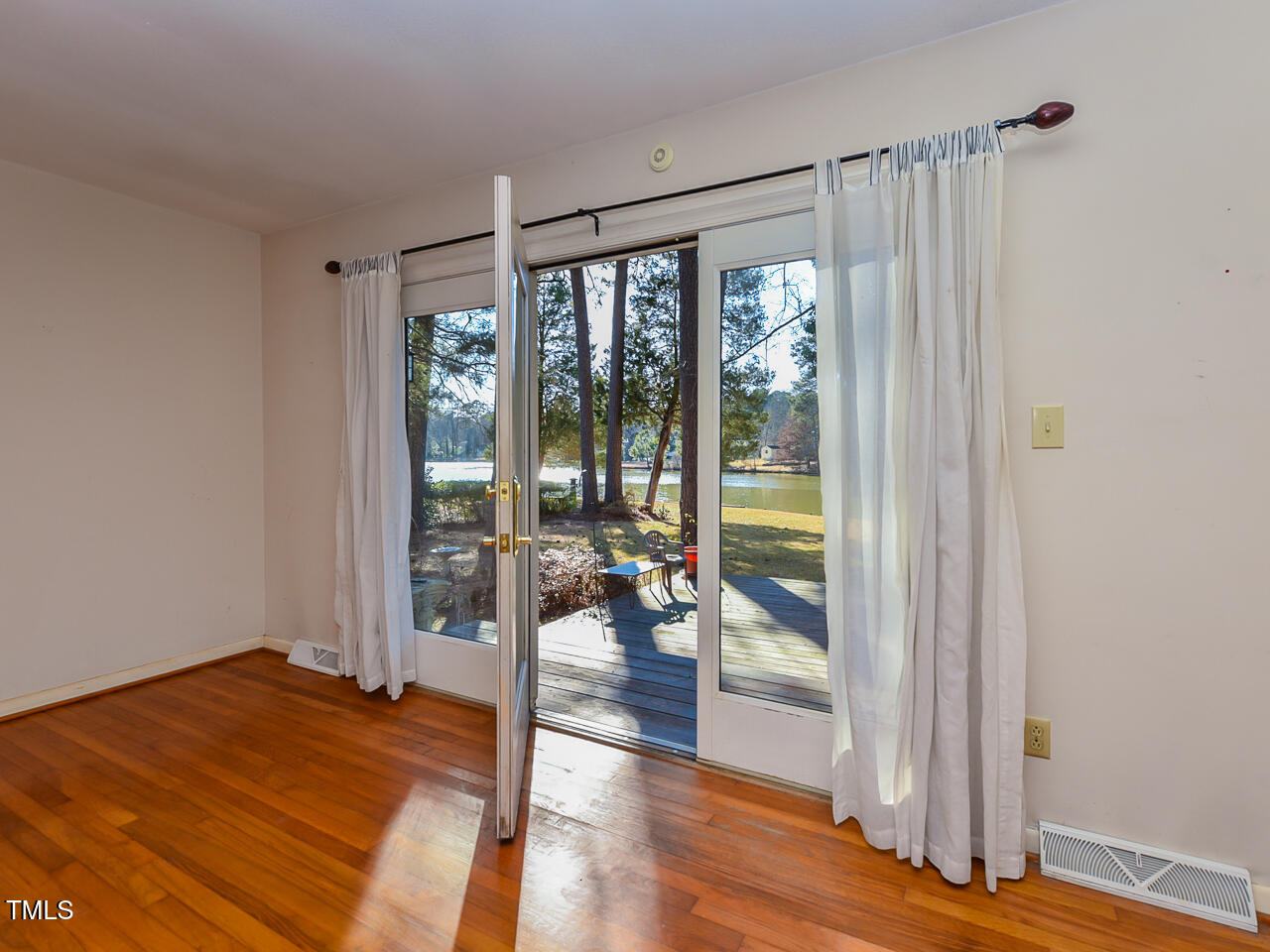5200 Newhall Road Durham, NC 27713 - Photo 33 of 35 a bedroom with a large window and a wooden floor