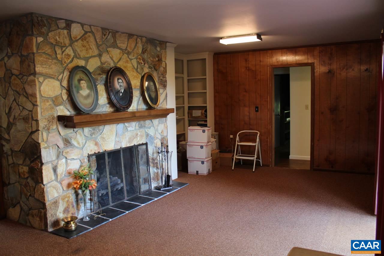 303 Evans Mill Road Dillwyn, VA 23936 - Photo 7 of 14 a view of an empty room with a fireplace and a fan