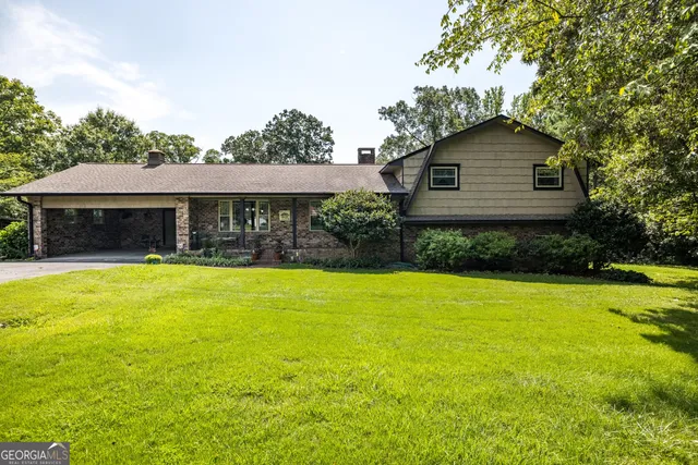 a kitchen with stainless steel appliances granite countertop a stove a sink dishwasher a dining table and chairs a refrigerator with wooden cabinets