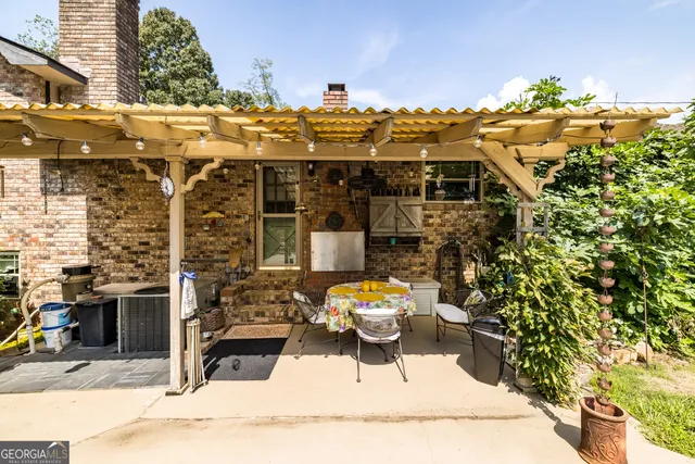 a view of a house with a yard plants and large tree