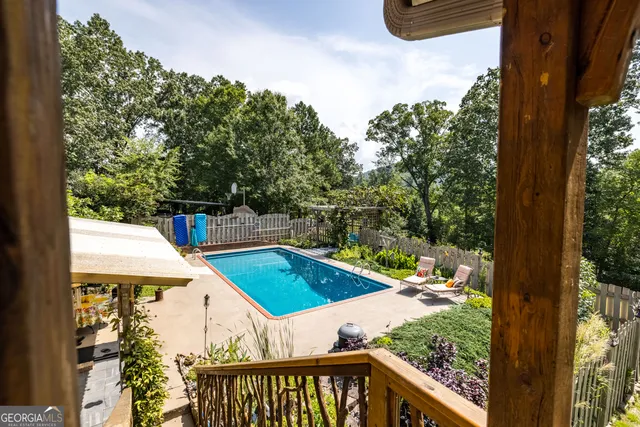 a view of a swimming pool with a patio and a yard