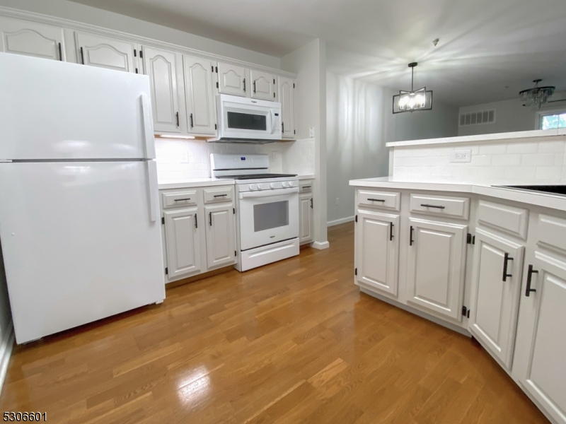 49 Potomac Drive Bernards, NJ 07920 - Photo 3 of 14 a kitchen with kitchen island a white cabinets and refrigerator