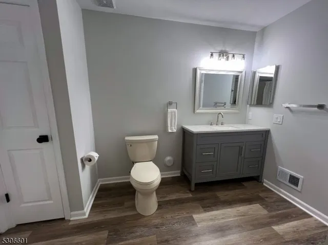 a spacious bathroom with a toilet sink and mirror