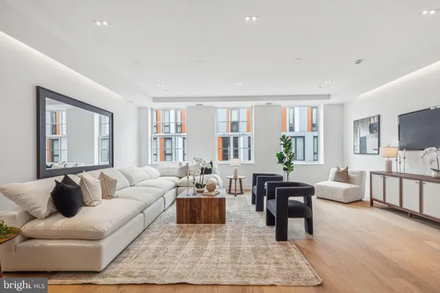 a living room with furniture wooden floor and a large window