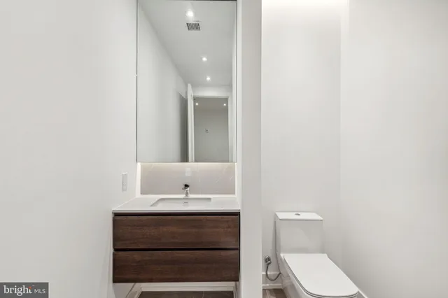 a bathroom with a sink a toilet and mirror
